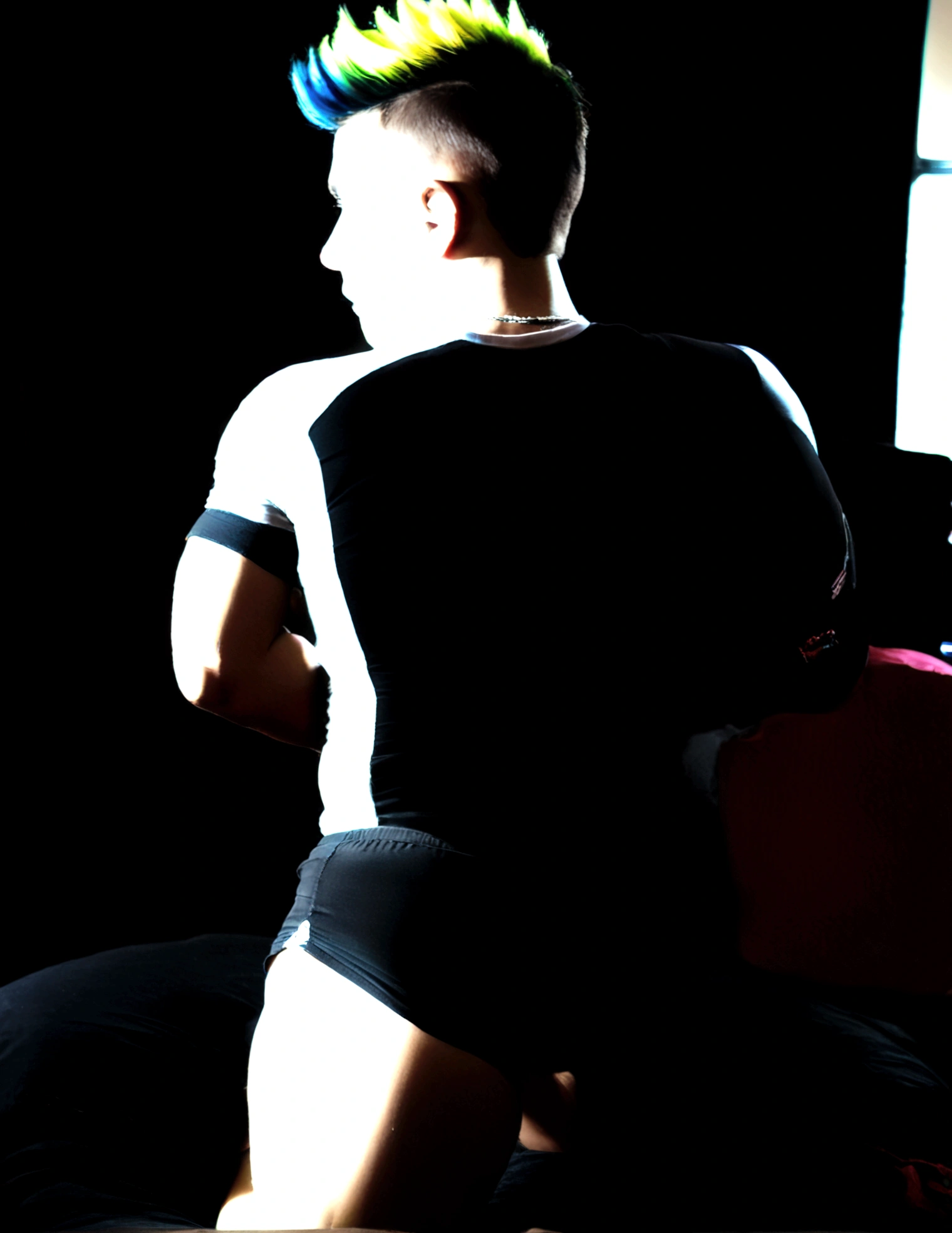 View from behind of a gay crossdressing punk-rock femboy slut in his bedroom he is on his knees bent forward with his back arched his legs wide spread twerking shaking his round sexy butt as his tiny cock and balls hang slightly out of his panties in the front barely visible between his legs as he looks back at us