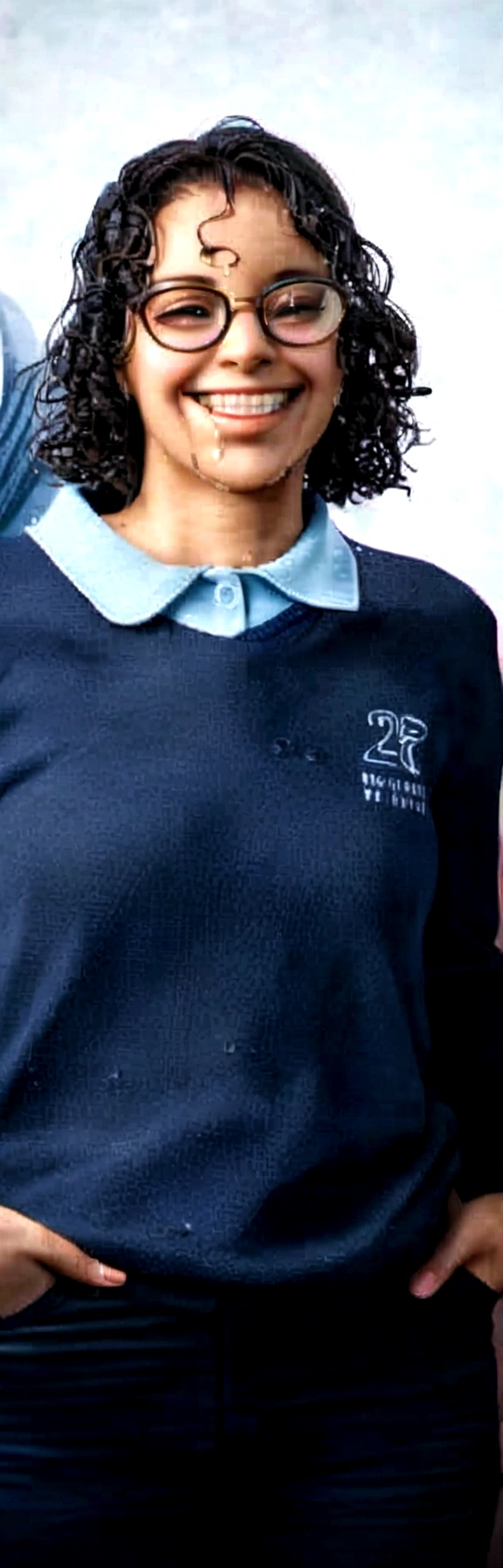 thin girl with glasses on her face, with wet hair, with her hand in her pocket, braces on her teeth and smiling