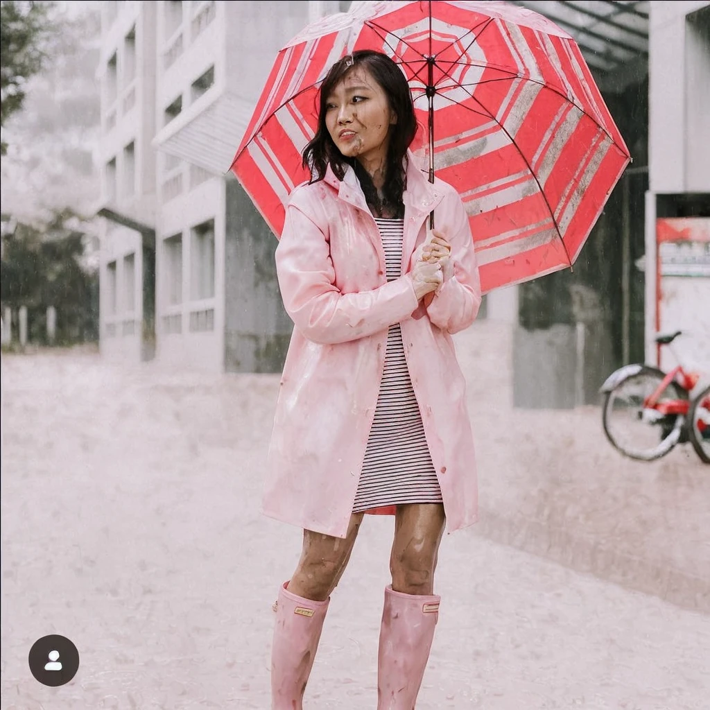 asian lady holding umbrella, cute pose, pink buttoned raincoat, tall pink rain boots, ((((muddy clothes)))), intricate details, highly detailed, masterpiece, 8k, photorealistic, cinematic lighting, vibrant colors, soft focus, elegant, feminine, beautiful, serene, graceful