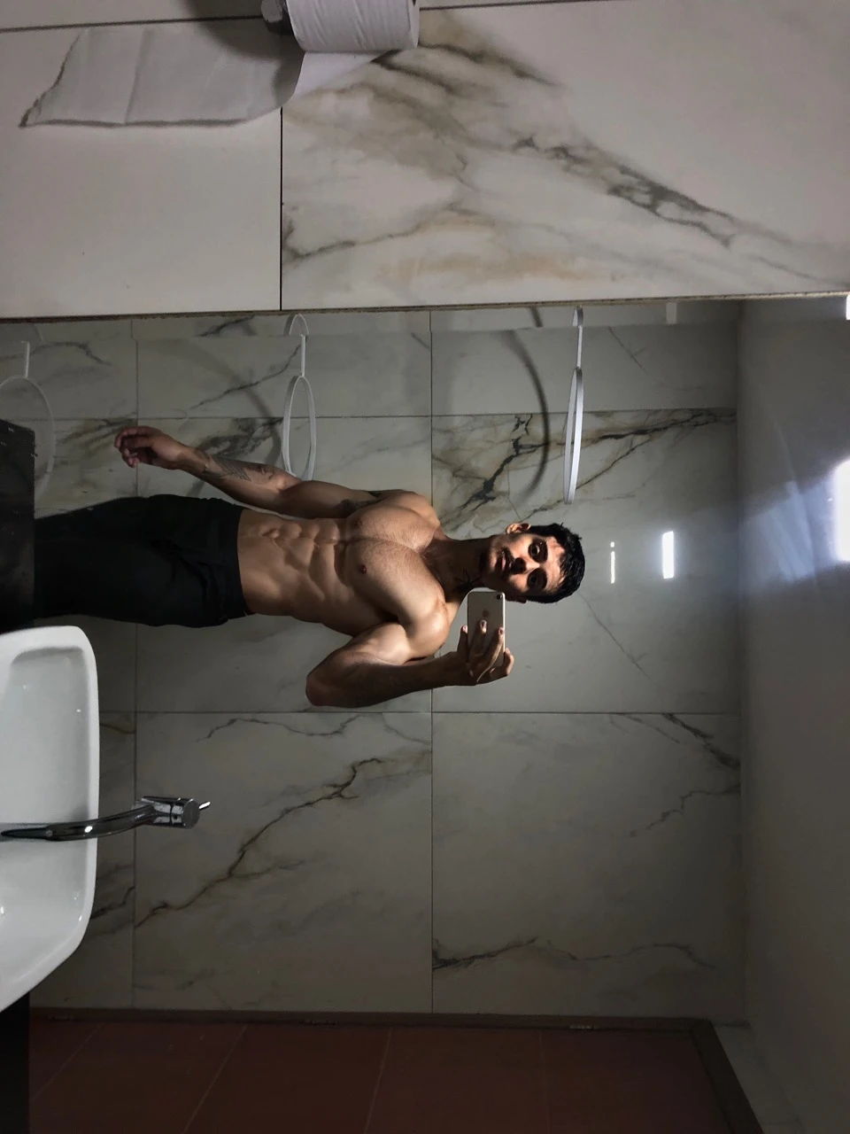 a 17 year old boy,short black hair,intense blue eyes,intense gaze,defined facial features,no facial hair,tall muscular build,broad shoulders,v-shaped body,wolf tattoo on right arm,full body focus,completely hairless,(best quality,4k,8k,highres,masterpiece:1.2),ultra-detailed,(realistic,photorealistic,photo-realistic:1.37),portrait,cinematic lighting,dramatic shadows,dynamic pose,highly detailed