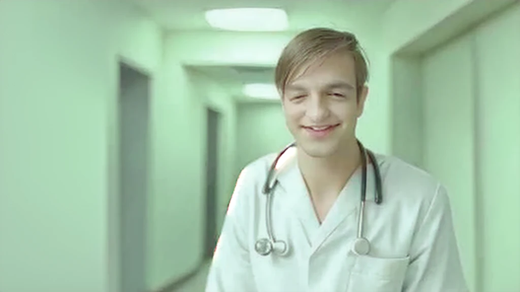 young, handsome doctor smiling in hospital corridor,