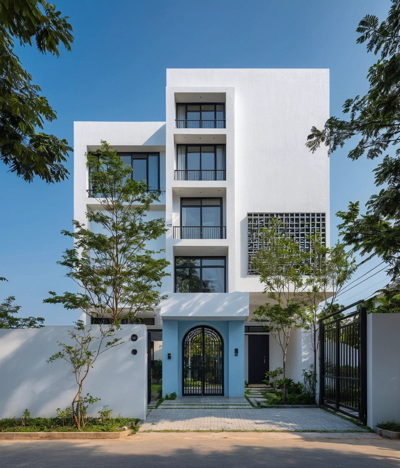 RAW photo, A white minimalist modern house with a double floor and simple architecture, surrounded by trees in a Vietnamese yard, with a black metal gate and fence, landscape design, natural light, clear blue sky, blue background, high resolution photography, architectural photography, architectural appearance. The building has square windows and doors made from wood, while the walls have a lattice design, There is also an entrance to another house nearby in the style of architectural photography, roads, sidewalks , sidewalk tree, 8k uhd, dslr, soft light, high quality, film grain, Fujifilm XT3