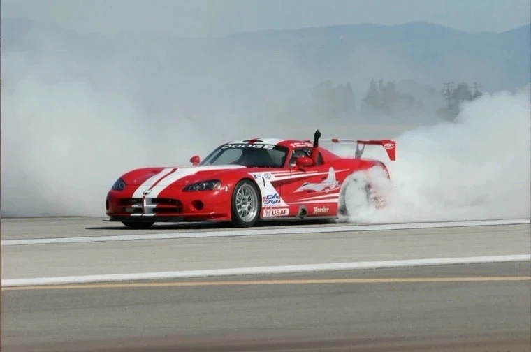 a high-speed race track, detailed race cars with sleek aerodynamic designs, crowds of spectators cheering, dramatic lighting, cinematic camera angles, motion blur, dynamic and intense energy, cinematic lighting, ultrarealistic, vibrant colors, photorealistic, 8k, best quality, highly detailed
