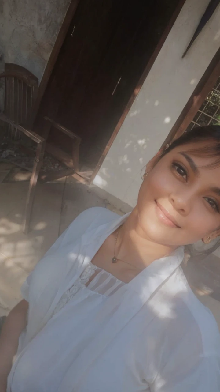 A charming indian woman, with an Off-the-shoulder shirt, Pelvic Curtain, necklace, Portraiture, bracelet, Cowboy Shot, Seductive pose, smile. Her soft dimples and realistic expression lines add authenticity. Her skin is illuminated by the sun's rays, highlighting her beauty. She is dressed in long, sophisticated clothes. In the background, there is a chaotic structure with multiple entrances, almost in ruins, surrounded by dense and branched vegetation. To capture this extraordinary scene, a high-resolution camera such as the Phase One XF IQ4 150MP is required. The lighting is diffused and natural, minimizing harsh shadows. The camera settings include a medium aperture, adjusted shutter speed, and a high-quality wide-angle lens with a focal length of approximately 35mm to capture the entire scene in an immersive way. Sharp, precise details are captured, from wavy hair to complex clothing patterns, ensuring a natural and stunning image.