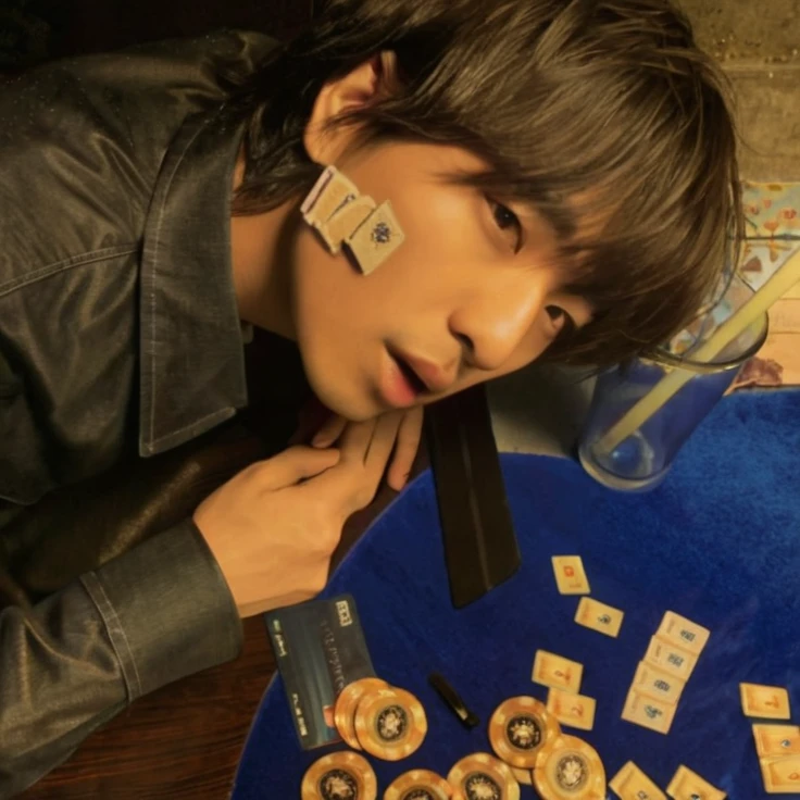 There is a man on a table on which there are cards and chips, Asian man, otherwise p1 harmony, cara sexy, asian features, Koreans, sexy, otherwise, otherwise, p1 harmony
