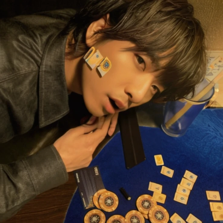 There is a man on a table on which there are cards and chips, Asian man, otherwise p1 harmony, cara sexy, asian features, Koreans, sexy, otherwise, otherwise, p1 harmony