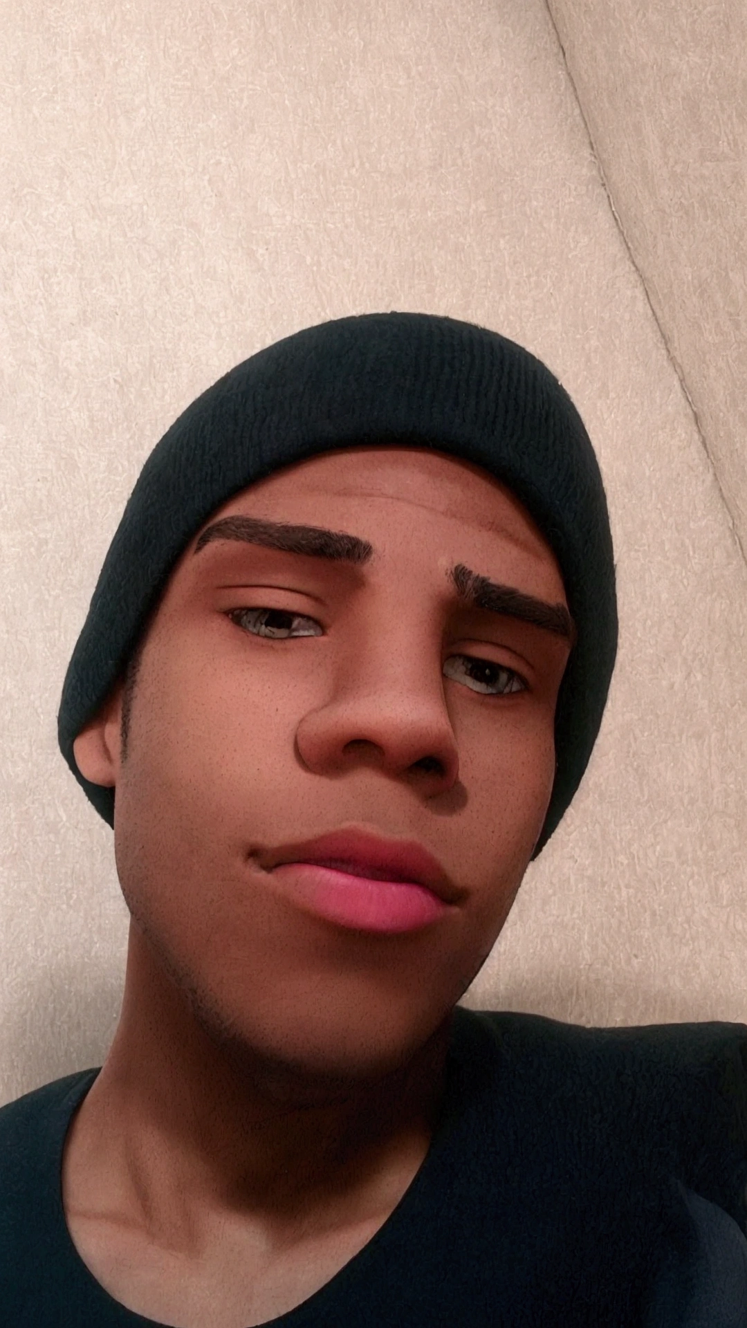 There is a man with a black cap and a black shirt, about 19 years old, taken at the beginning of 2020, clean shaved face, brown teenager, man with cold skin, around 20 years old, handsome pink mouth