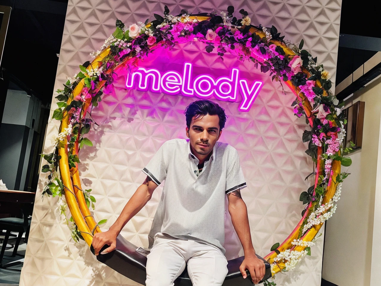 “Generate an image of a man wearing a stylish, tailored black suit with a white dress shirt and a black tie. Use the provided picture of the man to ensure his facial features and hairstyle are accurately represented. The setting should be a professional studio backdrop with soft lighting to enhance the formal attire.”