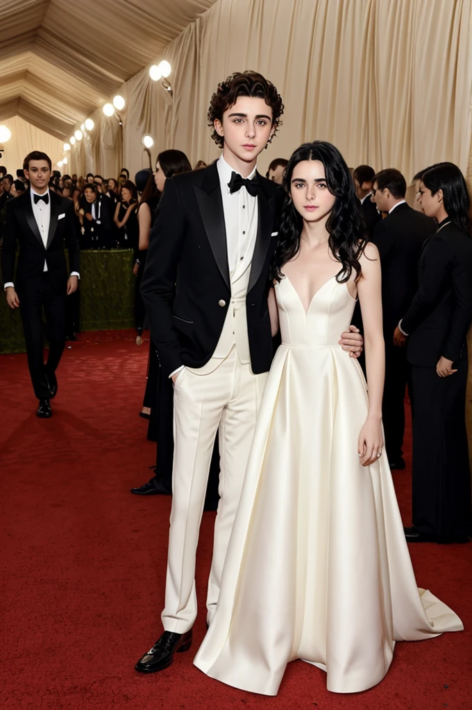 Timothée Chalamet wearing an elegant suit posing next to a cute girl with long, wavy black hair wearing a white dress. Met Gala stage, piano completo.