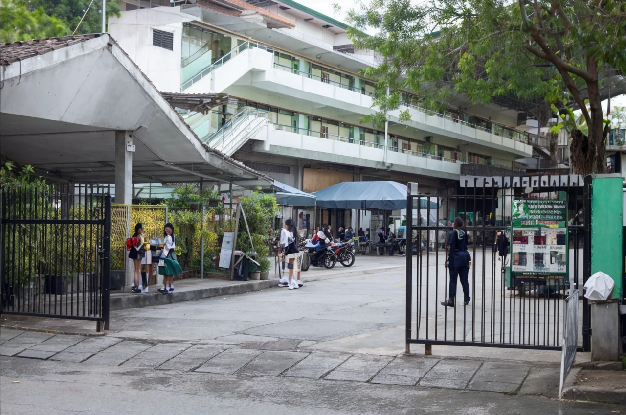 Add a student wearing sa cream uniform top checkered green yellow skirt that is going inside the gate