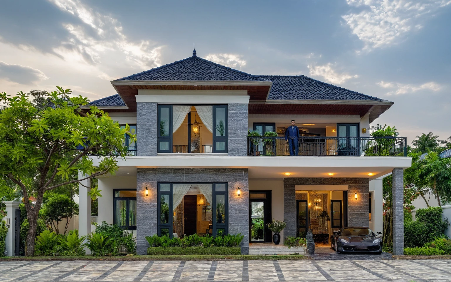 (masterpiece:1.2), best quality, photo of A two-story modern house in VietNam with dark tiles on the roof., dark granite tiled wall, neo classic detail, tree and plant environment,daylight, streetcapes, natural light, vivid color, The exterior of an elegant single family home features large windows, a dark gray door frame.