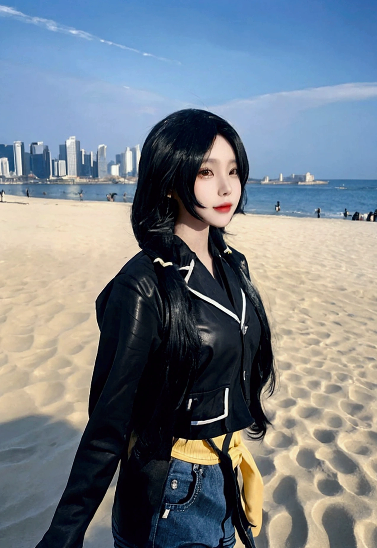 ultra-detailed, highly detailed,nbest quality, masterpiece, illustration, 
A young individual with long, black hair stands on a sandy beach with the ocean in the background. They are wearing a black leather jacket with yellow accents, a black crop top, and blue denim shorts. An umbrella and some stone structures are partially visible behind them. The weather appears sunny and clear.