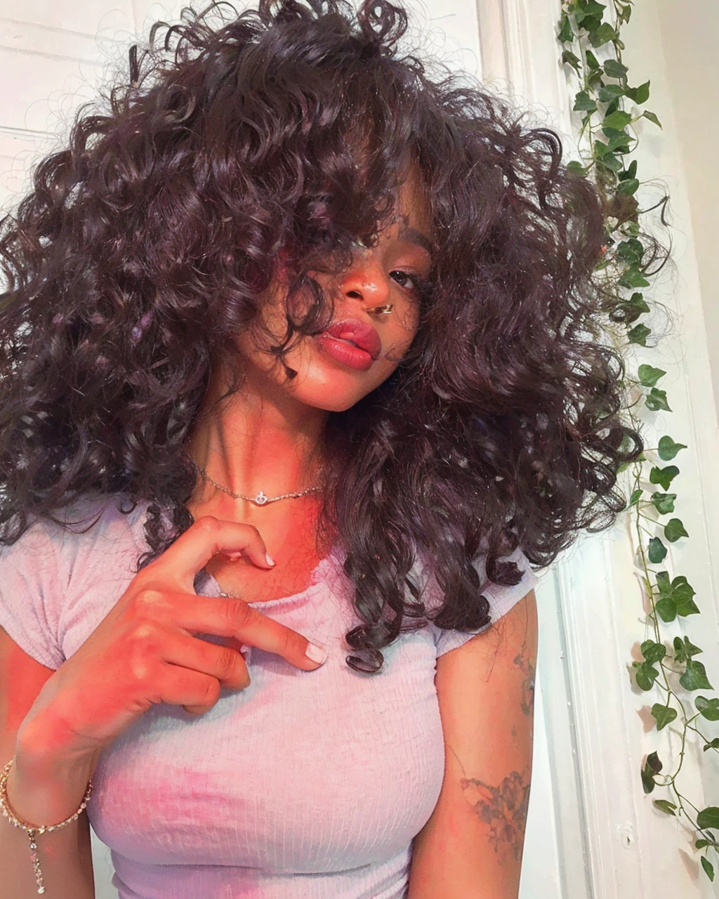 A black woman, com cabelo crespo, com olhos castanhos, wearing purple blouse. 