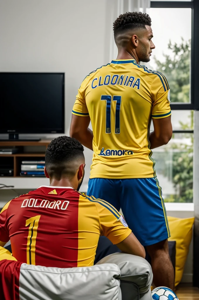 Man with his back to the television watching a soccer game wearing a Colombia shirt with the name Diego number 10