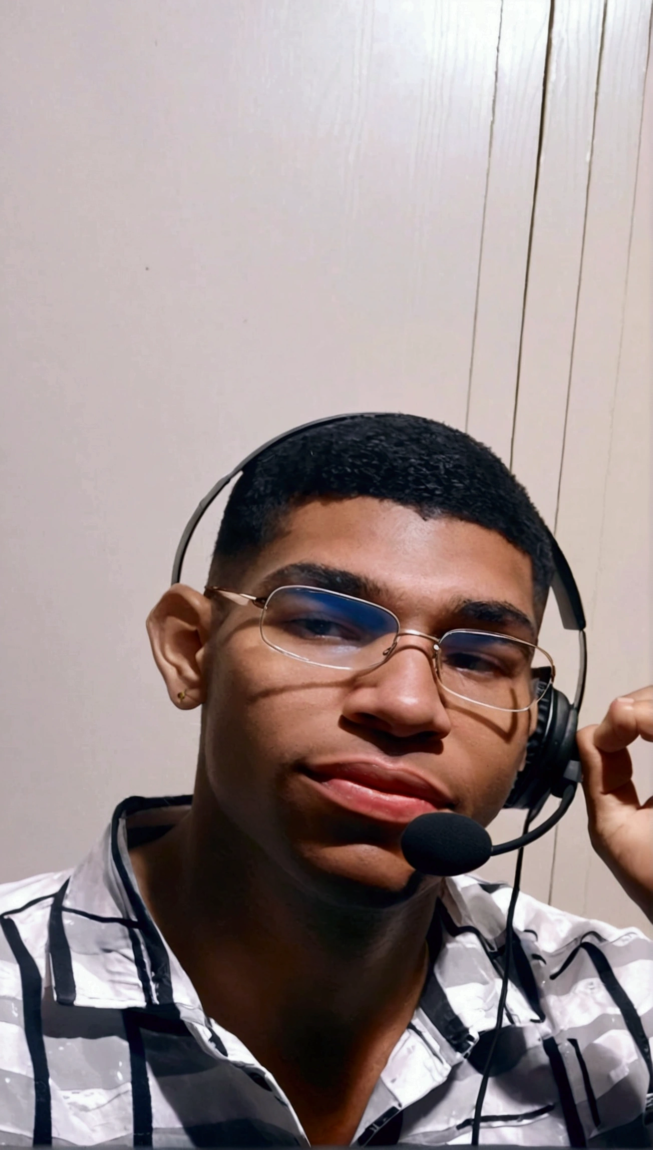 sitting in a gaming chair playing video games with a headset on his head and a joystick in his hand