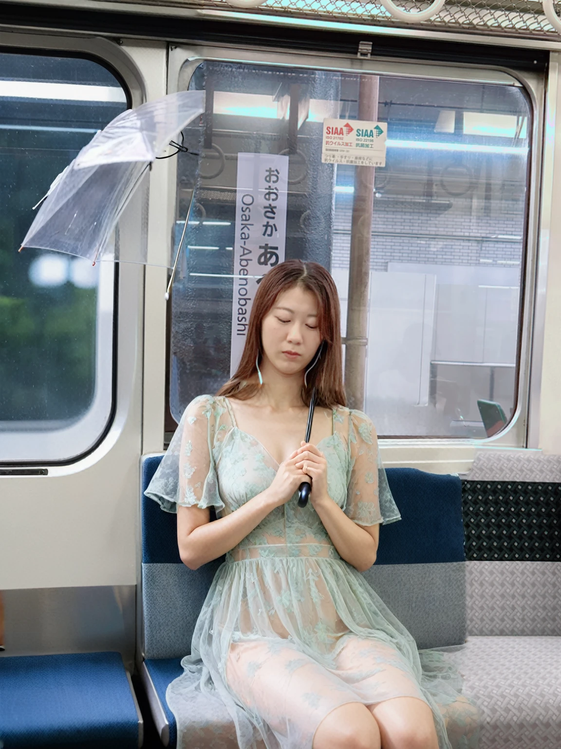 A woman wearing a see-through dress sitting on a train seat、Hold an umbrella、Sleeping