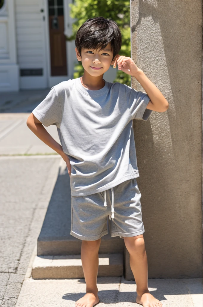 A tanned 12-year-old Japanese boy modeling in shorts during summer vacation Grey shirt and beige shorts