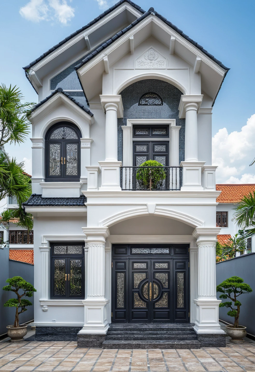 (bright image), A double story modern style house in the middle of Vietnam, (dark grnite tiled wall),(classic detail), simple and elegant architecture with white walls on top half and grey tiles roof, large windows with, entrance door is white with arched shape, bonsai trees, wide tile stone courtyard, professional photography, daylight, natural light, high resolution photography, (best quality, ultra realistic, masterpiece:1.15)