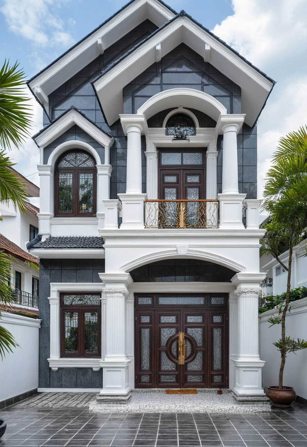 (bright image), A double story modern style house in the middle of Vietnam, (dark grnite tiled wall),(classic detail), simple and elegant architecture with white walls on top half and grey tiles roof, large windows with, entrance door is white with arched shape, bonsai trees, wide tile stone courtyard, professional photography, daylight, natural light, high resolution photography, (best quality, ultra realistic, masterpiece:1.15)