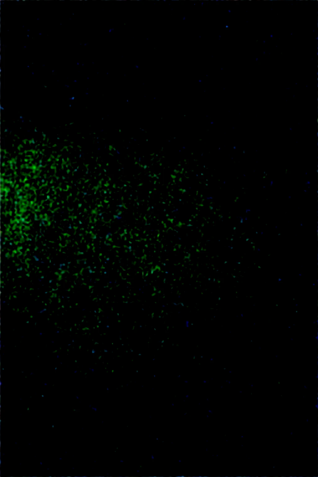 Boy in a dark room with green lighting, He is lying in bed and is looking at his cell phone