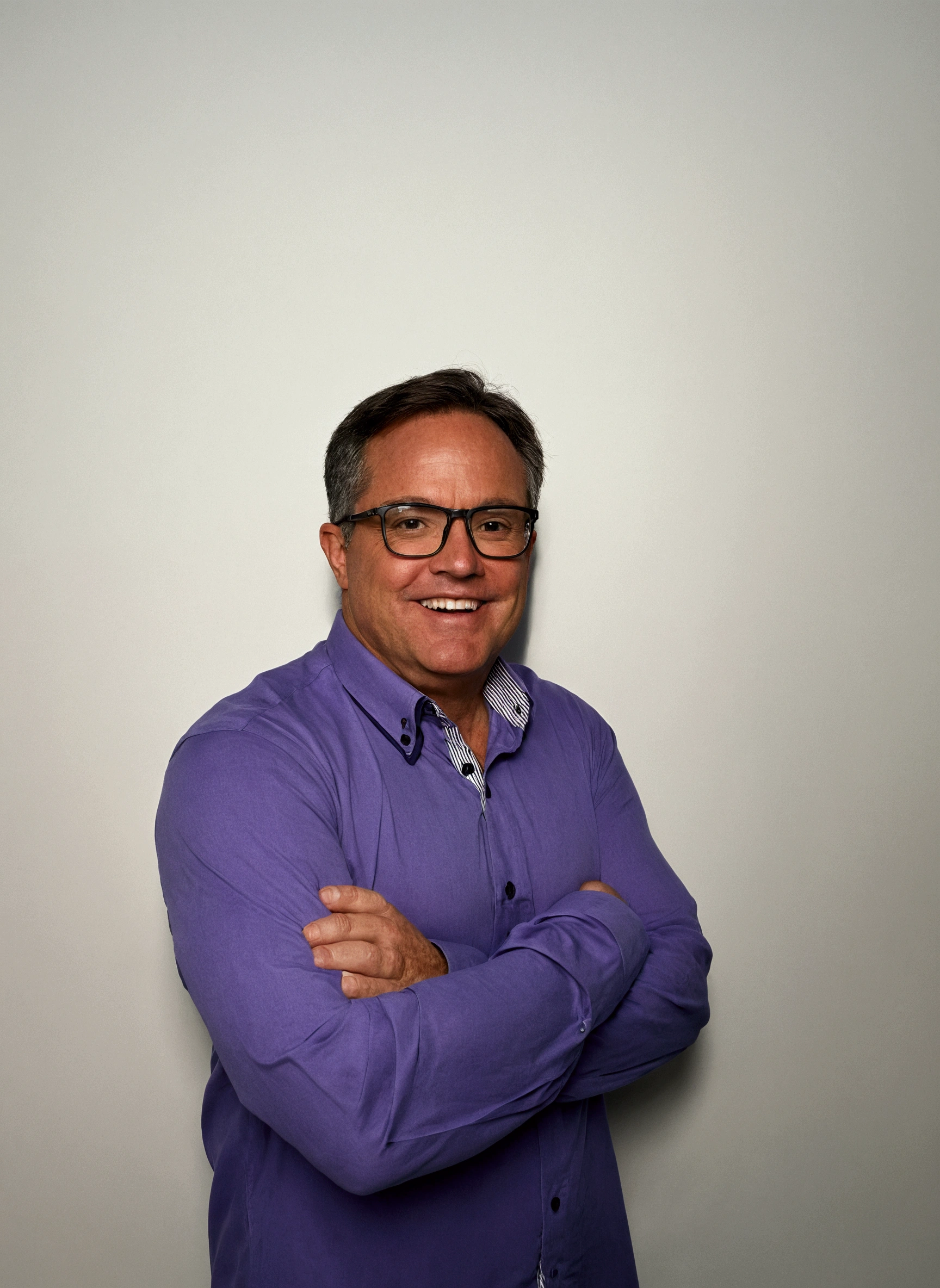 smiling man in purple shirt and glasses standing with arms crossed, Craig Russell, Steve Niles, in front of the white back drop, p. Craig Russell, Greg Rutkwowski, full body photo of steve, professional profile photo, Greg Rutkovsky, greg rutkowsi, Mike Franchina, photo of a man, tim hildebrant, commercial shot