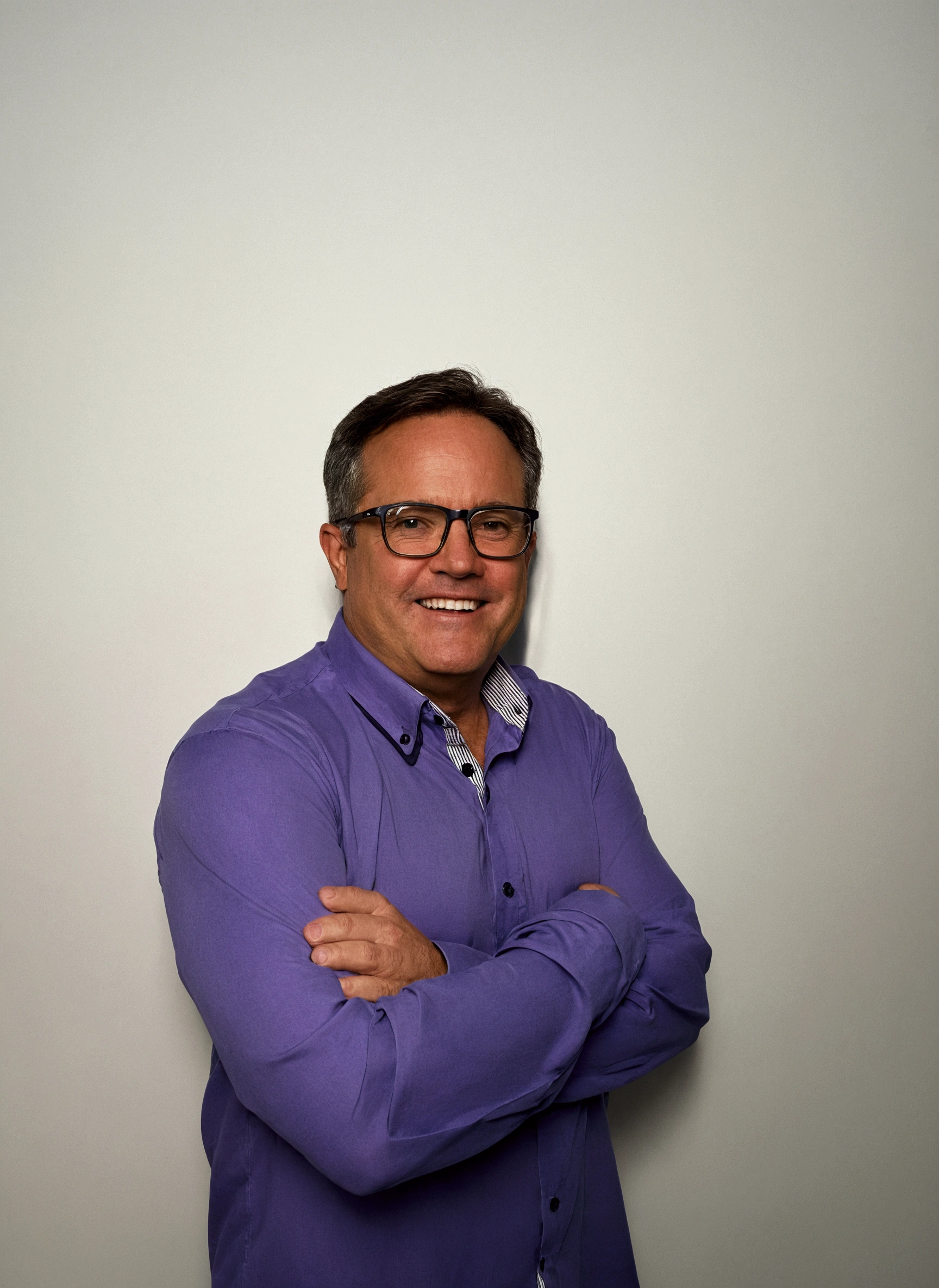 smiling man in purple shirt and glasses standing with arms crossed, Craig Russell, Steve Niles, in front of the white back drop, p. Craig Russell, Greg Rutkwowski, full body photo of steve, professional profile photo, Greg Rutkovsky, greg rutkowsi, Mike Franchina, photo of a man, tim hildebrant, commercial shot