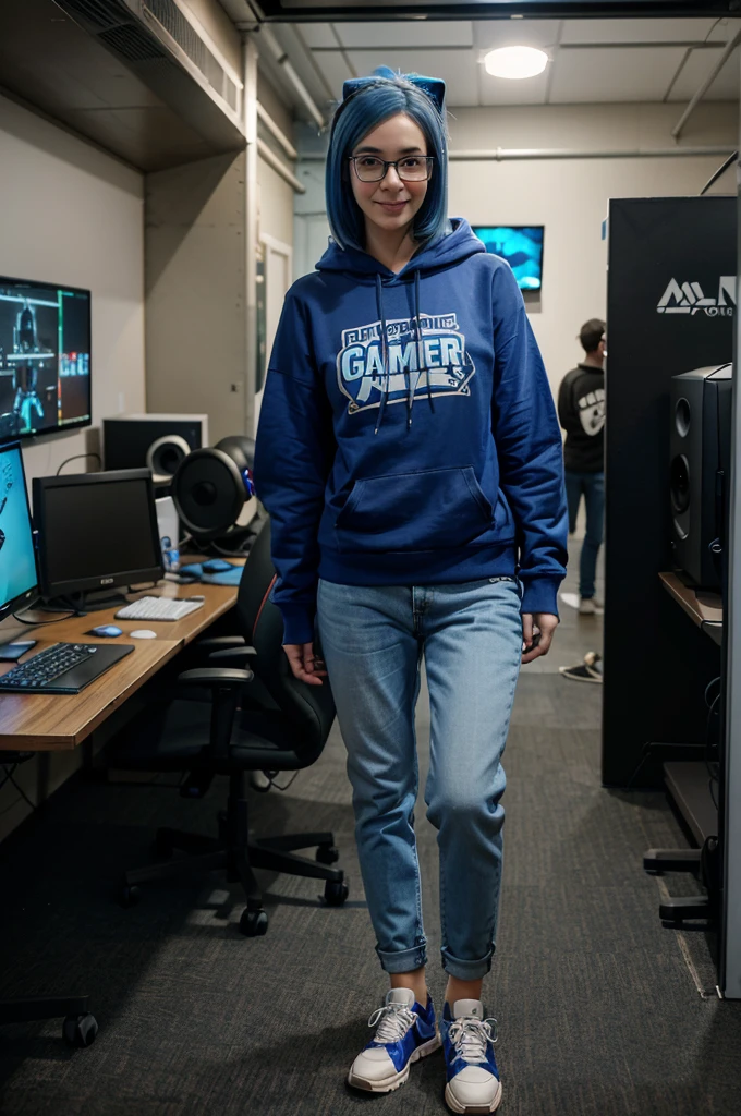 A full-body image of a slim woman with glasses, dyed blue hair, and an excited expression. She is dressed in a casual gamer outfit with a hoodie, jeans, and sneakers. She stands in a room filled with other gamers, computers, and cables, holding a game controller. The background shows a lively LAN party atmosphere