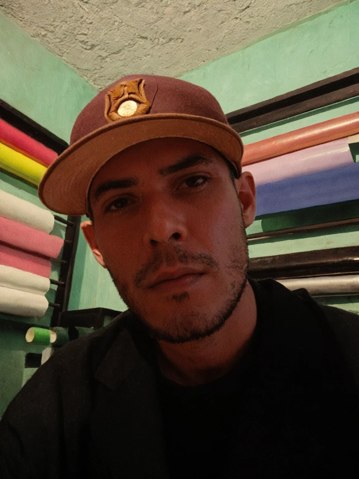 Arafed man with hat in front of a wall