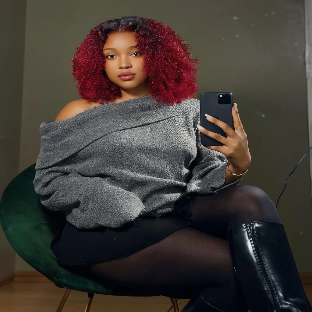 there is a woman sitting in a chair holding a cell phone, with curly red hair, red curly hair, with red hair, red afro, curly red hair, photo of a black woman, big red afro, selfie of a young woman, thick thighs, young black woman, she has red hair, red dyed hair, curly copper colored hair, black young woman