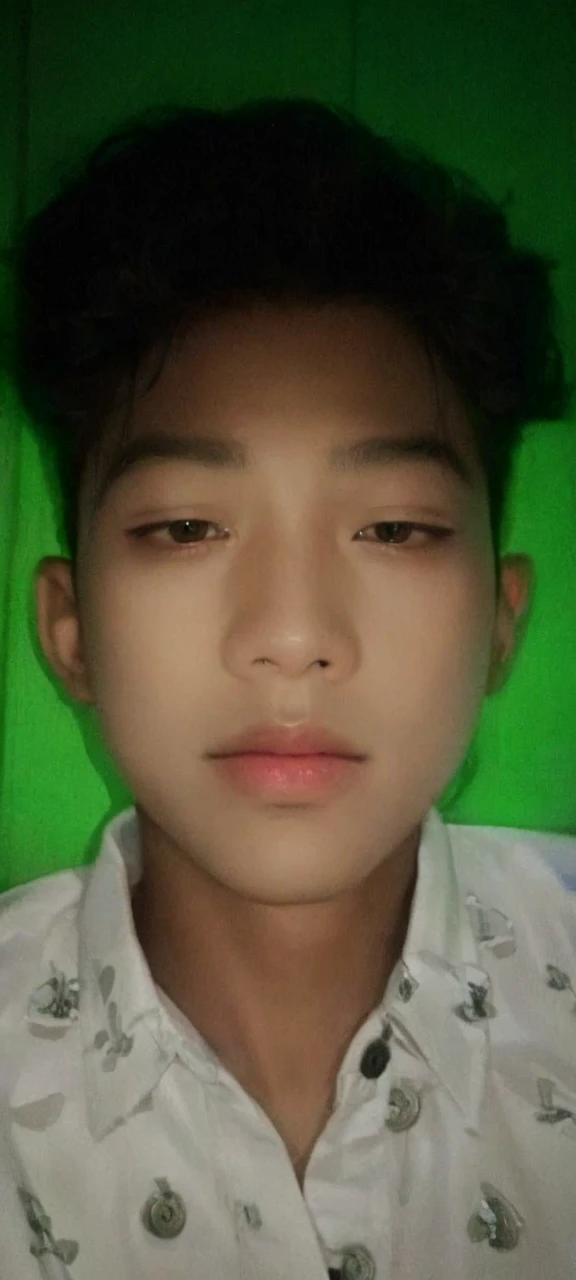 Realistic photos of (1 Cute Korean Male Celebrities) at eye level, sitting in front of a window with a coat on, a cigarette dangling from his fingers, and dim lights surrounding the scene. The clear facial features are showcased in crisp, lifelike details, making it an 8K high resolution masterpiece. Taken with an F/4.0 aperture and 135 mm lens on a FujiFilm camera, the jpeg artifacts and slight jitter add to the raw, authentic feel of the image. Ultra HD quality adds to the overall beauty and realism of this photorealistic portrait.