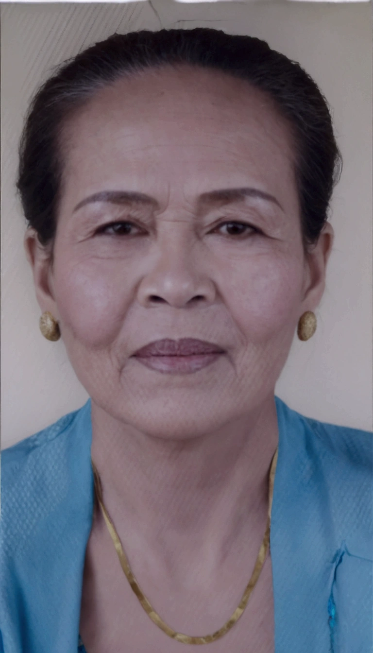 there is a woman with a necklace on her neck and a blue shirt, photo of a woman, taken in the early 2020s, portrait 6 0 - year - old woman, 60 year old woman wearing traditional Balinese kebaya, black earrings, gold necklace
