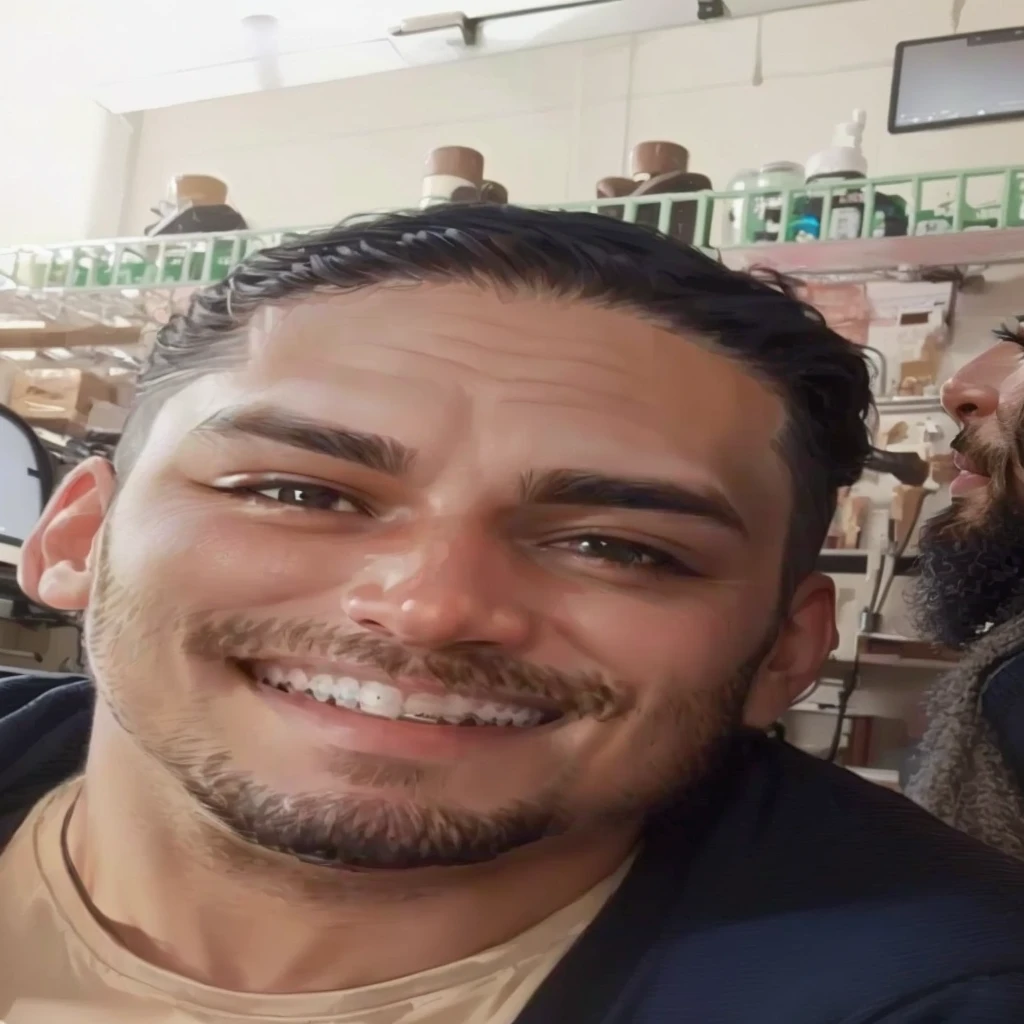 man sitting sideways, smiling with braces, beard only on his chin, background in a gamer room, maintaining photo identity