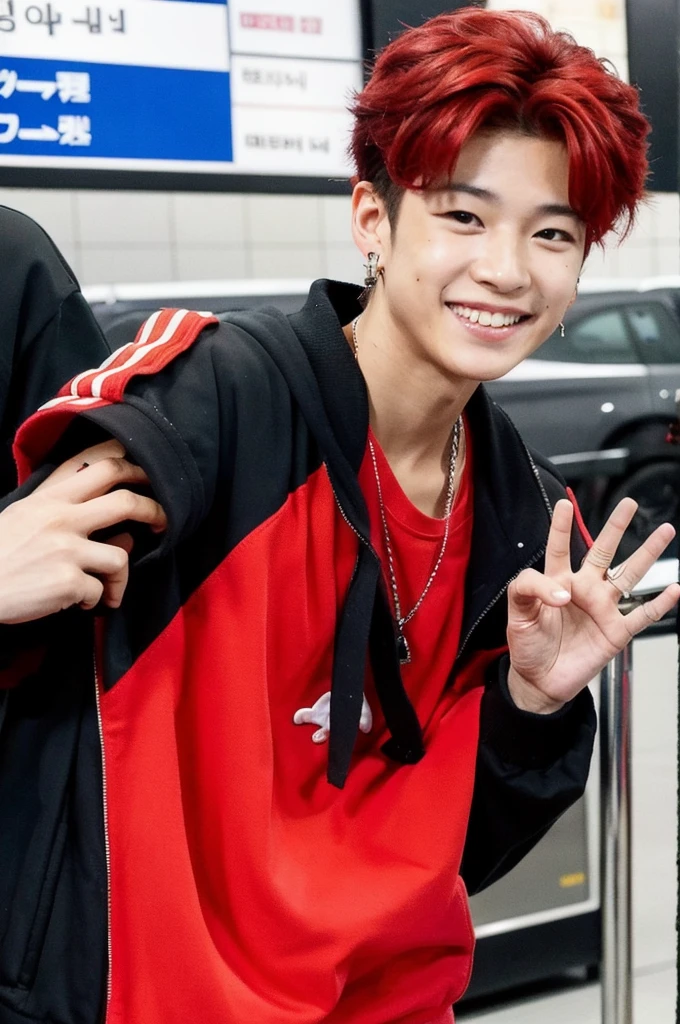 A Korean-Thai boy stands at the airport, smiles at the camera. He has red dyed hair and wears a hip-hop outfit. He also has an earring. Paparazzi take pictures of him. ￼