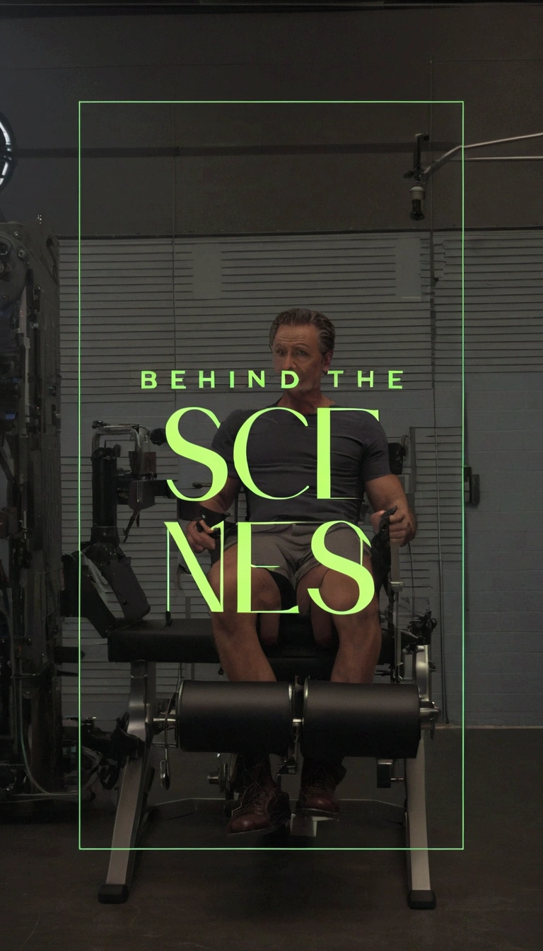 an image of a man sitting on a leg extention machine, behind the scenes, behind the scenes photography, meet the actor behind the scenes, behind the scenes photo, behind, in the background, scene, scenery, set photo, intense scene, detailed scene, complete scene, scenic, film scene, full scene shot, photo from behind
