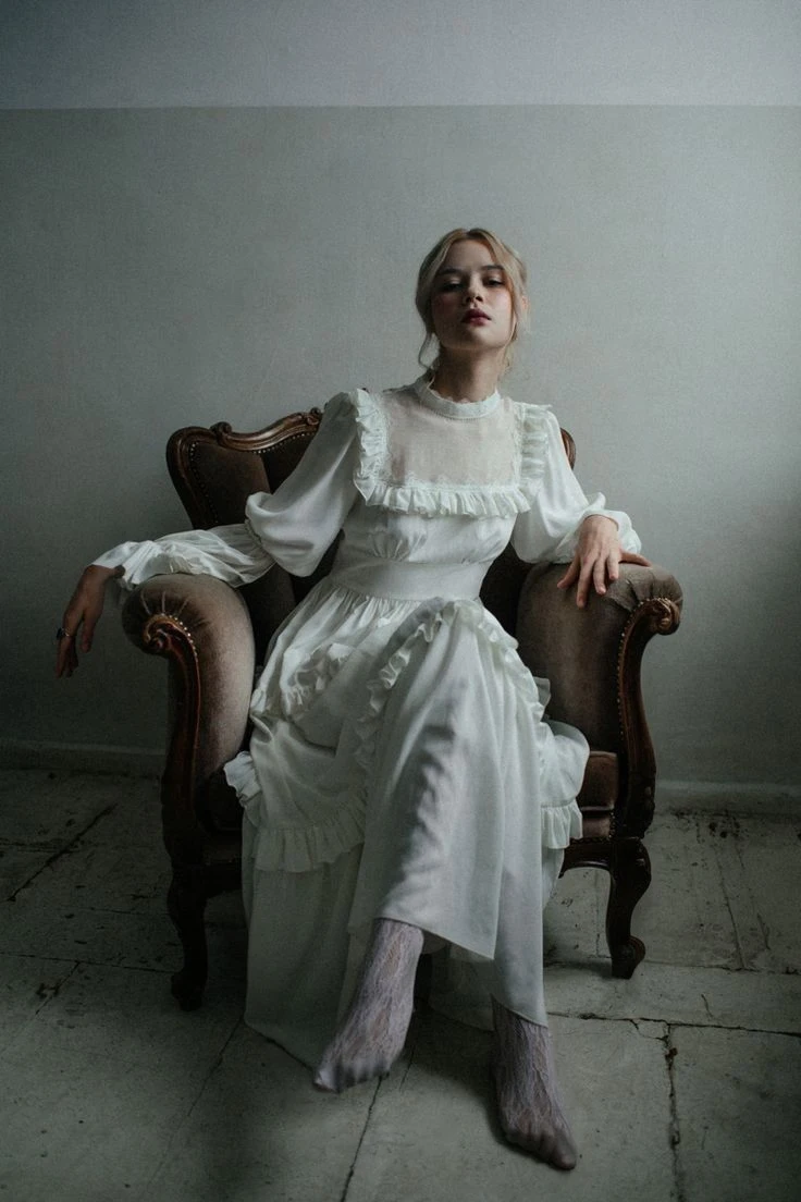 A 20 year old woman. Blonde Hair: Long and blond, often loose or styled into elegant hairstyles.Blue Eyes: Light blue eyes that highlight her angelic expression.Fair Skin: Fair and smooth skin, often described as porcelain.Height: 1.57 m, maintaining a graceful and delicate appearance. Delicate face: Delicate facial features with high cheekbones and an ethereal expression.