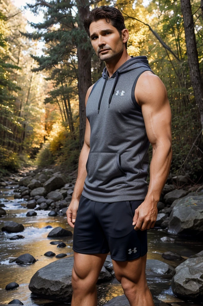 photo of eric bana a man wearing a sleeveless well-fitted under armour hoodie and compression shorts, standing on a boulder, outdoor trail, 35mm photograph, film, bokeh, professional, 4k, highly detailed, creek in the background, natural lighting, golden hour like me