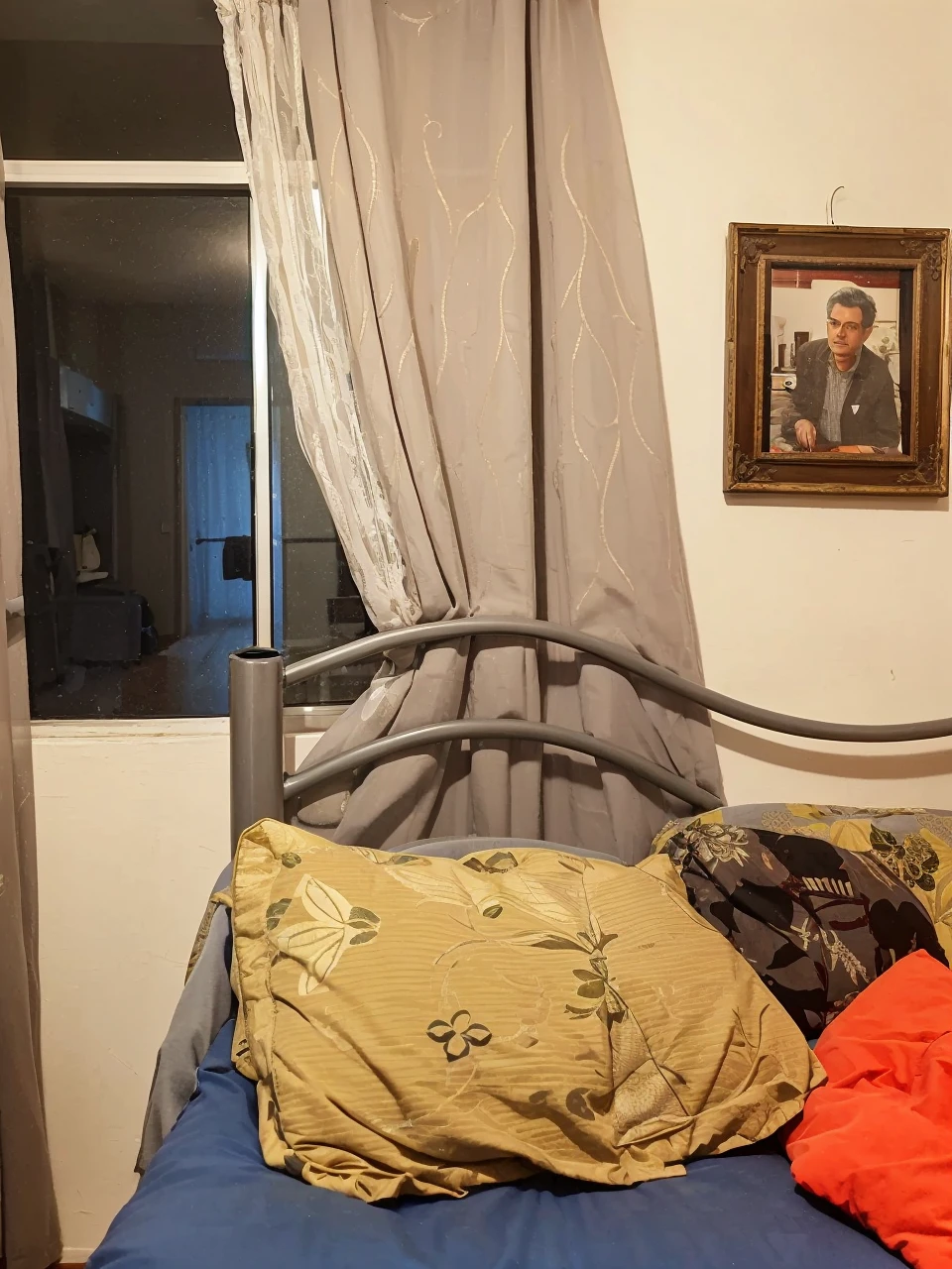Create an image of the interior of an ordinary apartment in the Colinas del Sur neighborhood of the Álvaro Obregón mayor's office in CDMX, overlooking Santa Fe, CDMX. This will show a dark room, a bedroom where the angle and position of the camera will be above the bed pointing at the window where you can see the city at night.