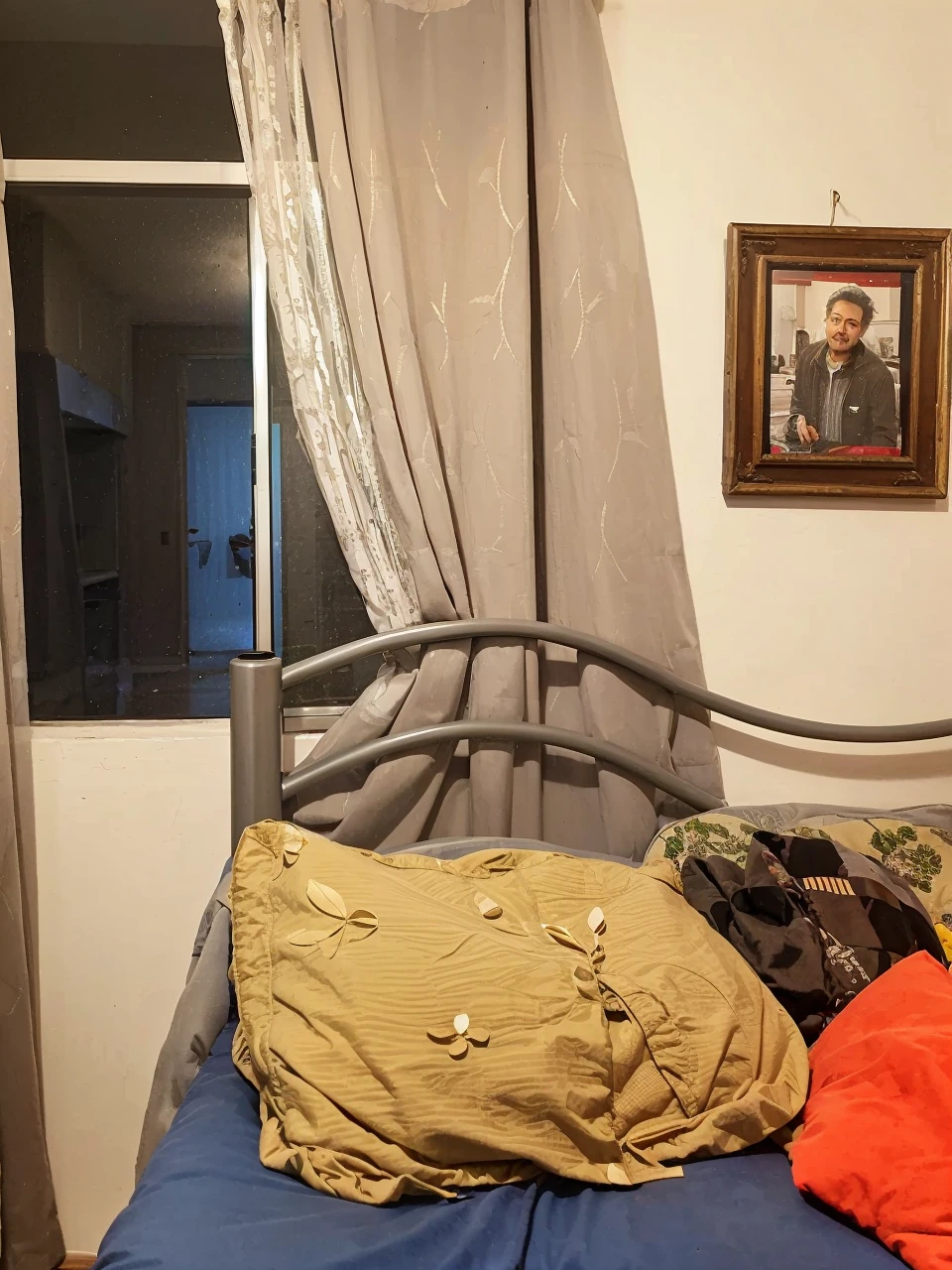 Create an image of the interior of an ordinary apartment in the Colinas del Sur neighborhood of the Álvaro Obregón mayor's office in CDMX, overlooking Santa Fe, CDMX. This will show a dark room, a bedroom where the angle and position of the camera will be above the bed pointing at the window where you can see the city at night.