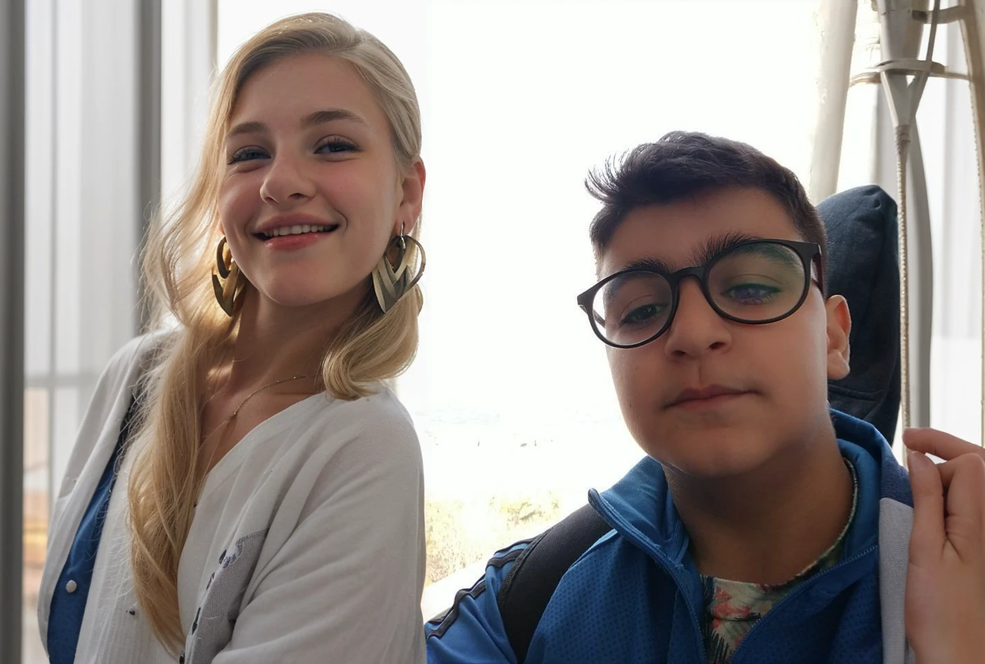 A 13-year-old blonde, white-skinned, beautiful and smiling girl, 150 cm tall, looking lovingly, with normal earrings and normal clothes.
