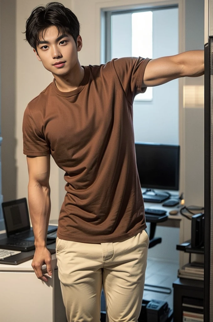 A young Asian man stands, handsome, muscular, looking at the camera. In a plain brown t-shirt, In the computer room