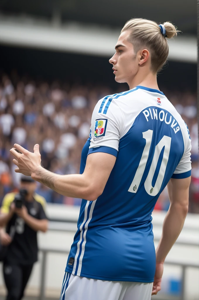 Young white man with side-swept hair and topknot entering a World Cup football stadium with his back showing the shirt number 10 and the name Paulo