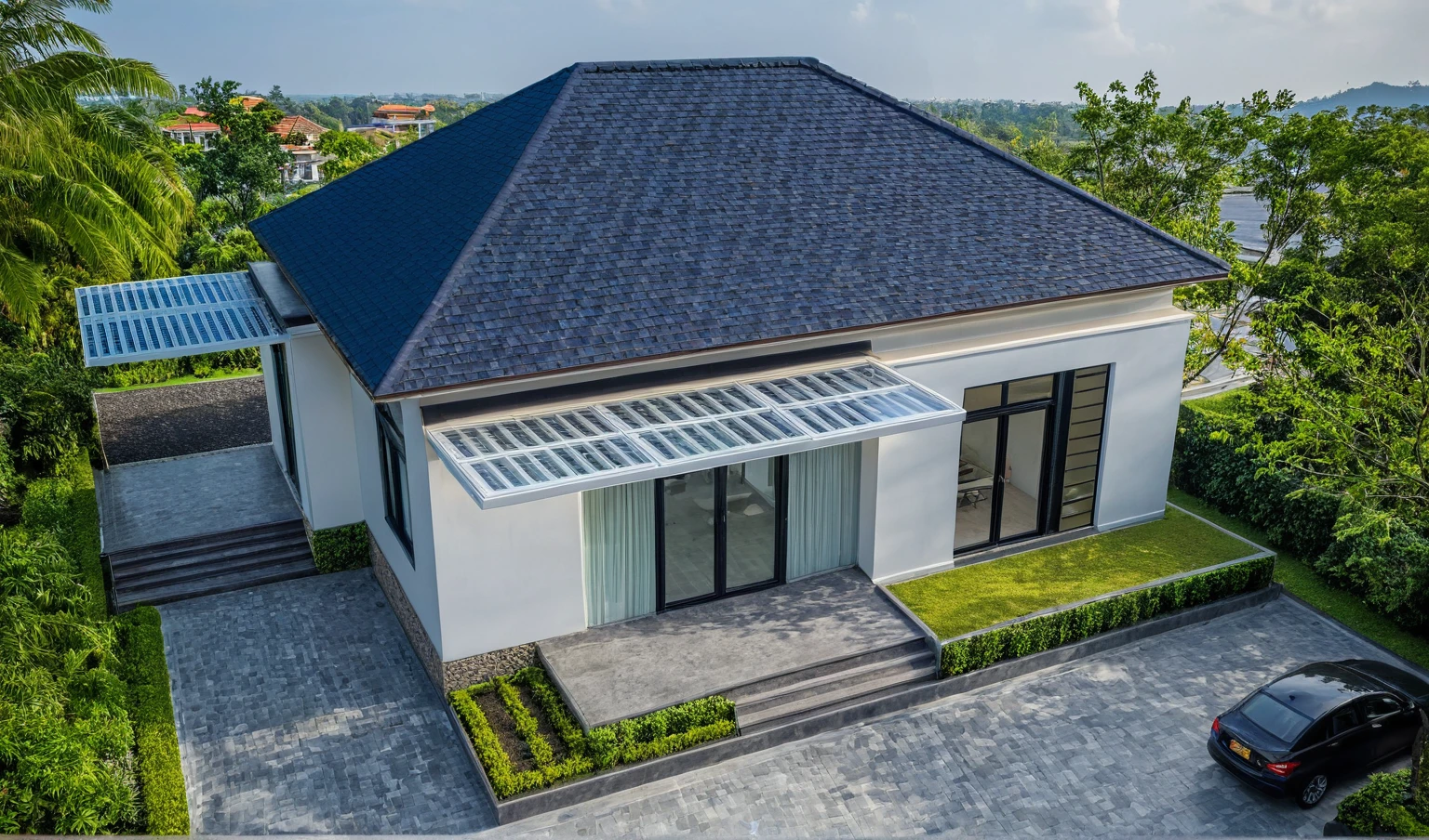 (masterpiece:1.2), best quality, photo of A two-story modern house in VietNam with white walls and dark tiles on the roof., tree and plant environment,daylight, streetcapes, natural light, vivid color, The exterior of an elegant single family home features large windows, a dark gray door frame.