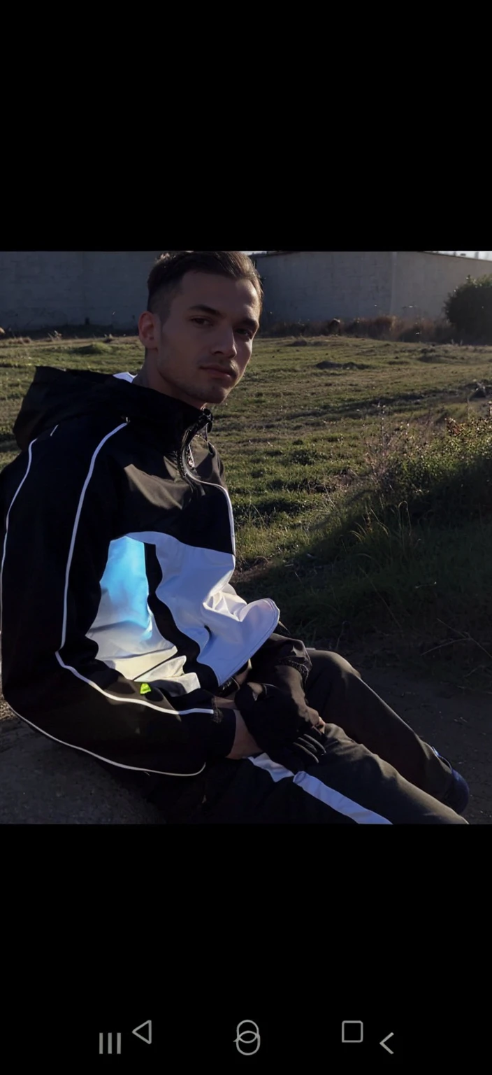 A guy in a tracksuit and a jacket half open 