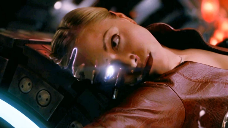 Blonde woman in leather jacket lying on a table with a glass of wine, Kristanna Loken, Natalie Portman and Star Trek, Movie still of a cyborg., Movie still of a cyborg alienígena., Movie still of a cyborg genial., iconic shot, science fiction movie frame, in a science fiction movie, MATRIX PHOTOGRAPHY (1999), shot in the face