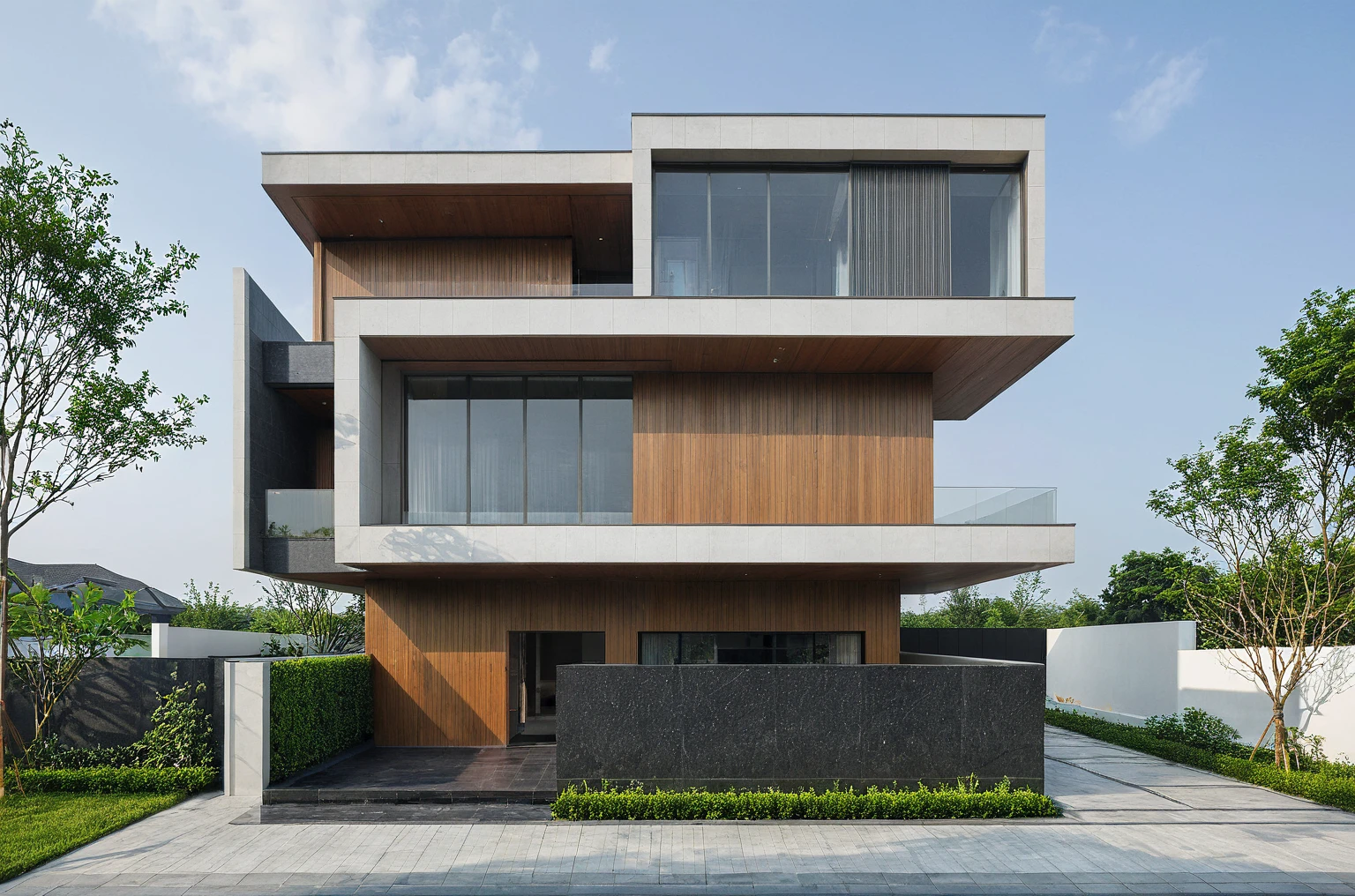 (masterpiece, best quality:1.2), exterior design, single 2 storie modern house on the Vietnam village, modern dark tiled granite and white walls facade, wooden ceiling, large glass, minimalist modern style, green shrubs and tropical tree background, ((natural light)), clear sky morning background, large door and windows,