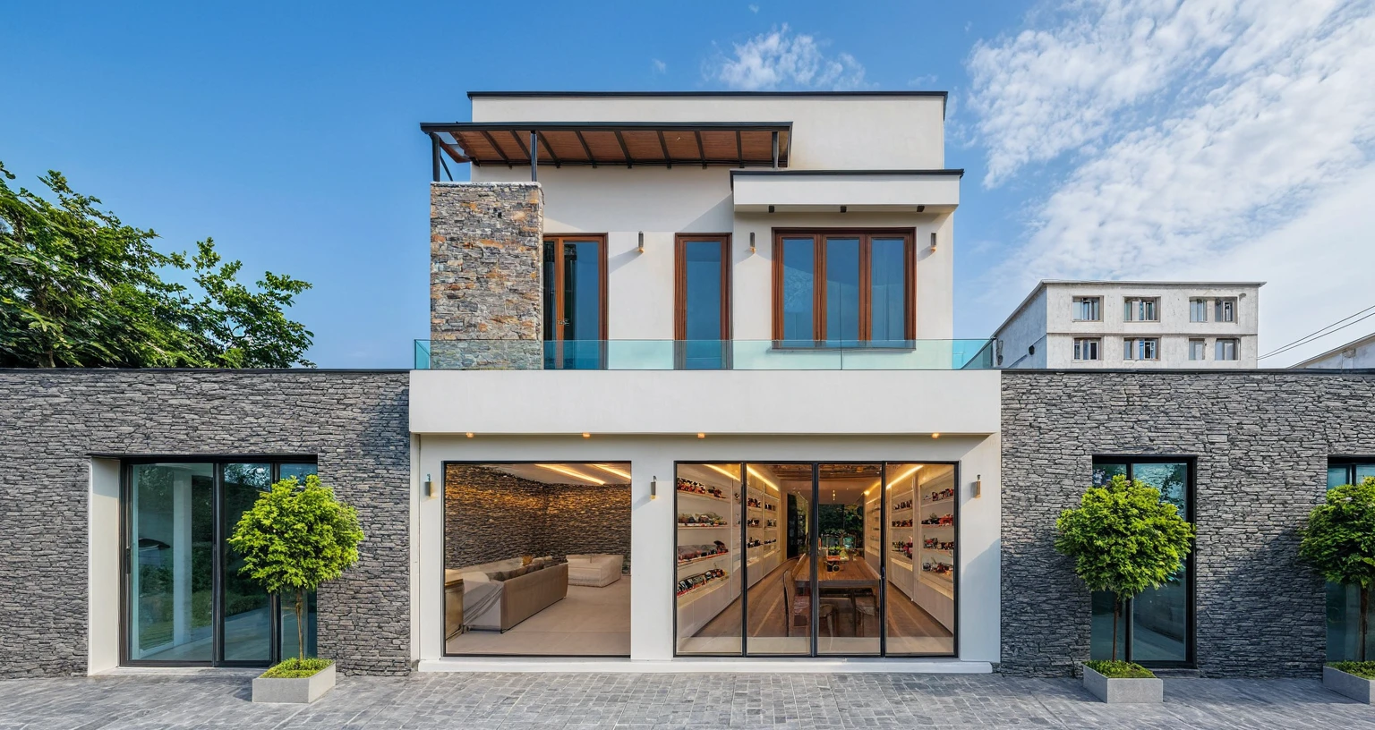 Two-story townhouse, Minimalist architecture, modern house, brightly painted walls, stone wall accents, xingfa aluminum glass doors. The canopy is made of durable iron glass. Vào buổi chiều, Construction lights are turned on and you can see the furniture, The first floor is where the business is located, The second floor is the residence. actual representation. surreal house
