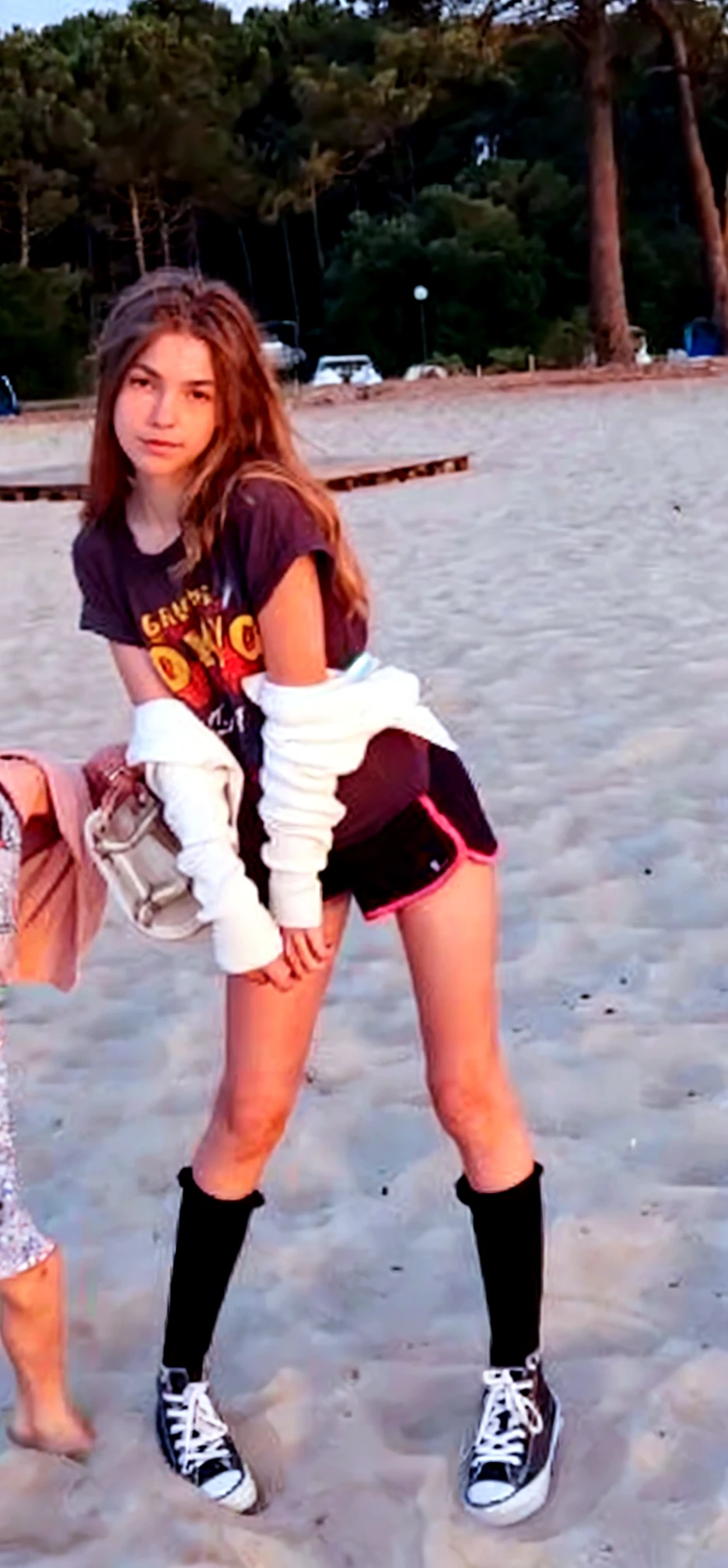 18 year old Cindy,wearing short jeans,sneakers,white stockings and a pink tanktop on the beach.