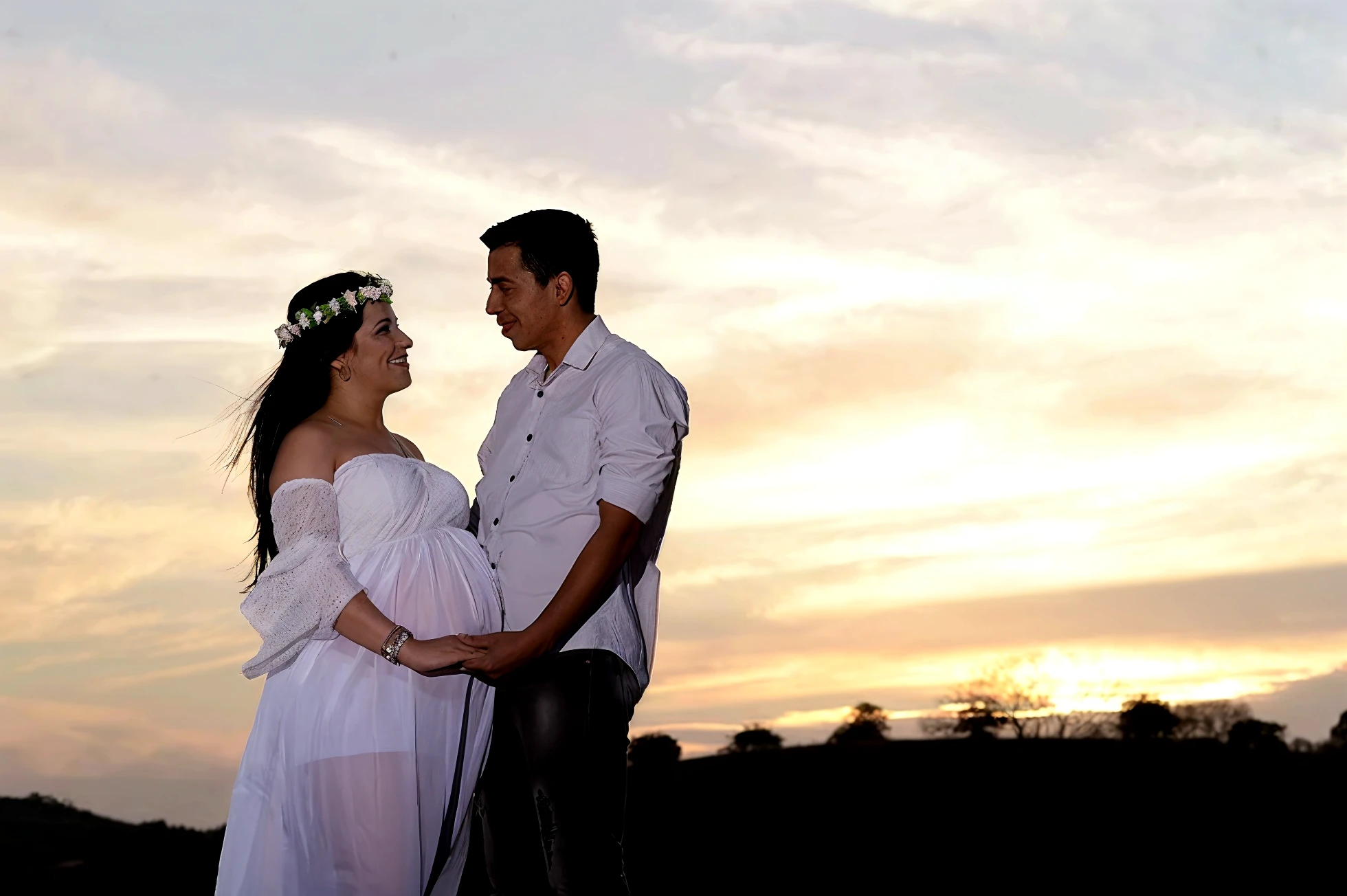 There is a man and a woman standing in front of a circular arch, com montanhas ao fundo, in a scenic background, Directed by: Nandor Soldier, com a terra ao fundo, com campos de flores em primeiro plano, background is celestial, com montanhas como pano de fundo, Lovely couple, 🤬 🤮 💕 🎀, Edon Guraziu, pregnant belly, pano de fundo
