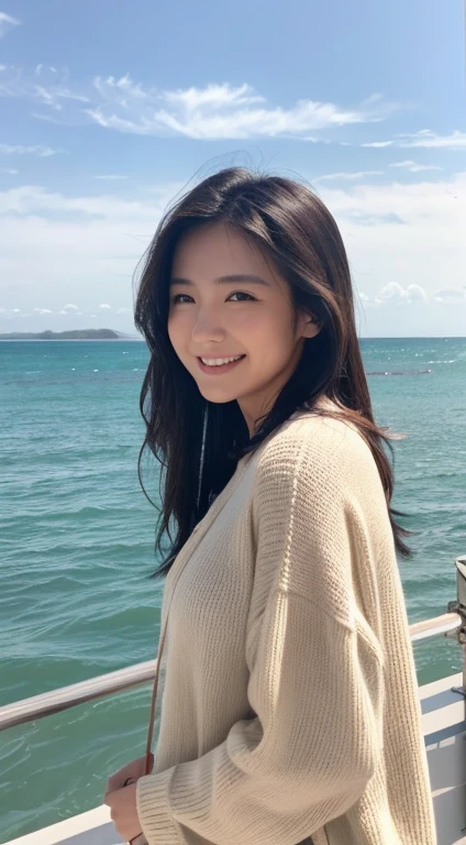 A woman looking at the camera with a natural smile。With a relaxed look、Long black hair。 Shooting at the beach with waves lapping in the background Shot from a low angle、The beach is the background。Natural light。