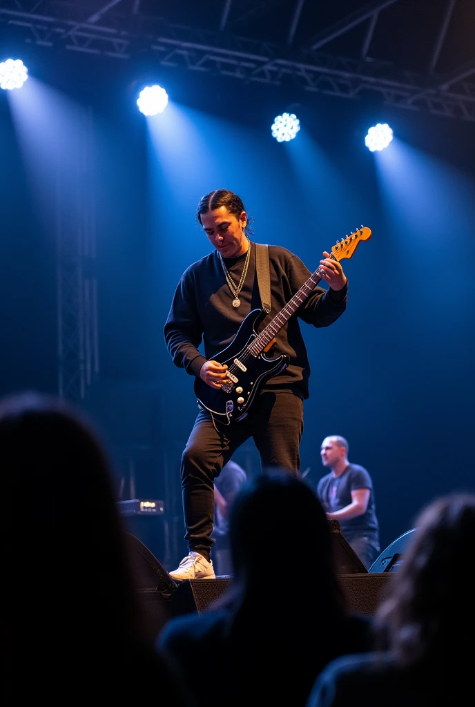 Un artiste même personnage qui fait du rap sur le paudium entrain de chanter . Qui porte une un pull noir et un tee-shirt camoufler qui déborde légèrement avec une casquette sur ses cheveux avec une mine serré fessant face aux publics assis sur une chaise avec une guitare 